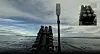 Mørkt utstyr og mast på dekk av et fartøy på åpent hav, med innfelt svart-hvitt bilde øverst til høyre.