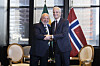 Jonas Gahr Støre håndhilser på Brasils president Lula foran norske og brasilianske flagg.