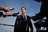 Marco Rubio taler til journalister med mikrofoner og telefoner foran seg ved et fly.