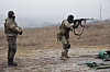 Russisk soldat skyter med gevær mens en instruktør står ved siden av på en øvingsplass.