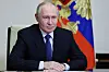 Vladimir Putin sitter ved et bord foran Russlands flagg under videomøte i sikkerhetsrådet.