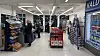 Kunder handler i en butikkgang med varehyller og kjøledisk merket «KALD».