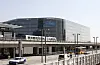 Rambøll-bygget i Ørestad med tog på høybanen og busser i gaten nedenfor.