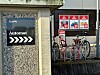 Skilt med «Automat» og piler ved parkeringsautomat, med sykler i stativ bak.