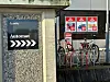 Skilt med «Automat» og piler ved parkeringsautomat, med sykler i stativ bak.
