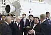 Vladimir Putin og Kim Jong Un med følge foran en rakett i en monteringshall.