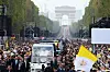 Pave Leo XIV vinker fra pavemobilen på Champs-Élysées med Triumfbuen i bakgrunnen.