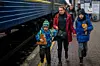 En kvinne gråter mens hun løper sammen med sine to sønner for å sette seg på et tog på vei til Lviv ved Kyiv-stasjonen, Ukraina, torsdag 3. mars 2022. Ukrainske menn må bli igjen for å kjempe i krigen, mens kvinner og barn forlater landet for å søke tilflukt i et naboland. Foto: Emilio Morenatti / AP