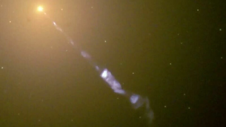 Slik ser midten av M87-galaksen ut med Hubble-teleskopet. Her kan du tydelig se den flere tusen lysår lange jetstrømmen som kommer fra det sorte hullet i midten.