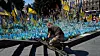 Tusenvis av ukrainske menn er drept ved fronten, mens tusenvis stadig sendes ut i kamp. Krigen har tappet det ukrainske næringslivet for arbeidskraft. Her viser en soldat sin respekt foran minnesmerket over falne soldater i Kyiv. Foto: Jefrem Lukatskyj / AP / NTB