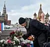 En kvinne legger ned blomster der Boris Nemtsov, en av Russlands mest kjente opposisjonelle, ble skutt og drept i 2015. En tsjetsjener ble funnet skyldig for drapet i fjor, men Nemtsovs familie mener de som ga ordren aldri ble tatt. Scanpix/AFP.