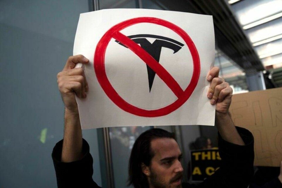 Demonstranter protesterer mot Tesla utenfor en Tesla-forretning i New York.