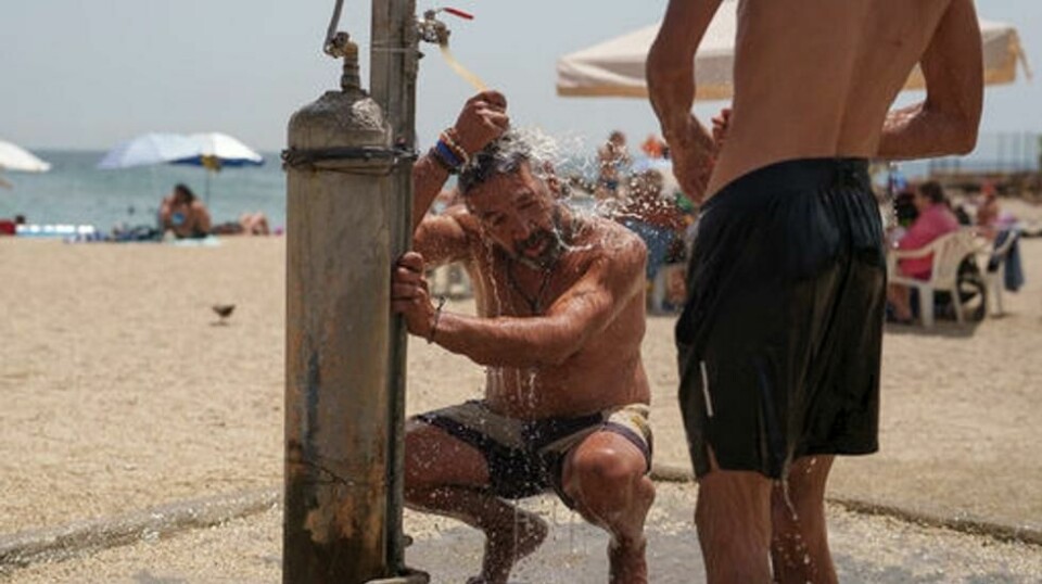 En greker kjøler seg ned i intens hete i Hellas, der temperaturene har passert 40 grader flere steder de siste ukene. Foto: Petros Giannakouris / AP / NTB