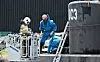 Bildet viser teknikere jobbe på Peter Madsen ubåt etter at den ble hevet. Foto: Jens Noergaard Larsen / AFP