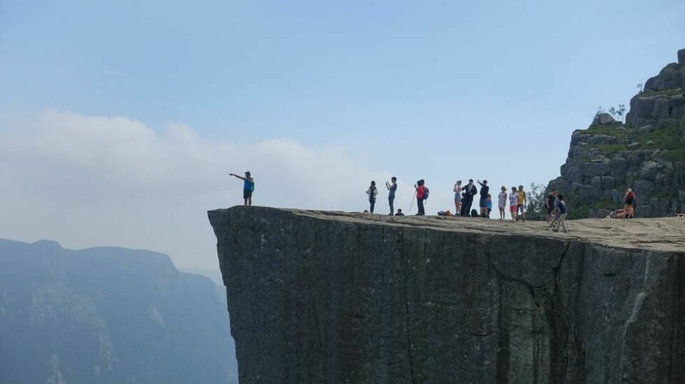 Turgåere på kanten av Preikestolen. Over 250 000 mennesker tar hvert år turen opp til fjellplatået på nordsiden av Lysefjorden i Forsand kommune i Rogaland. Foto: Marianne Løvland / NTB