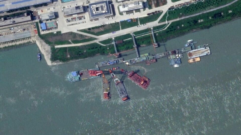 Satellittbilder viser flere kraner som tilsynelatende heiser opp en ubåt som ligger helt eller delvis under vann. Amerikanske tjenestepersoner mener en kinesisk ubåt sank mellom mai og juli. Foto: Planet Labs PBC / AP / NTB
