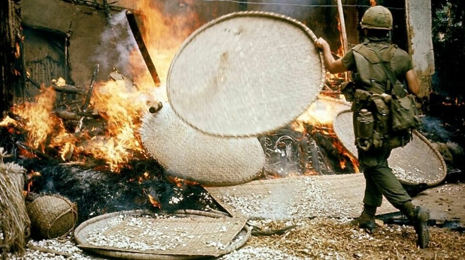 En amerikansk soldat kaster en bambus-kurv på et bål i My Lai. De amerikanske styrkene fikk ordre om å brenne ned hus, drepe husdyr, ødelegge matlagre og stenge brønner. Det kom også rapporter om at de kastet ned lik i brønnene for å forgifte vannet.