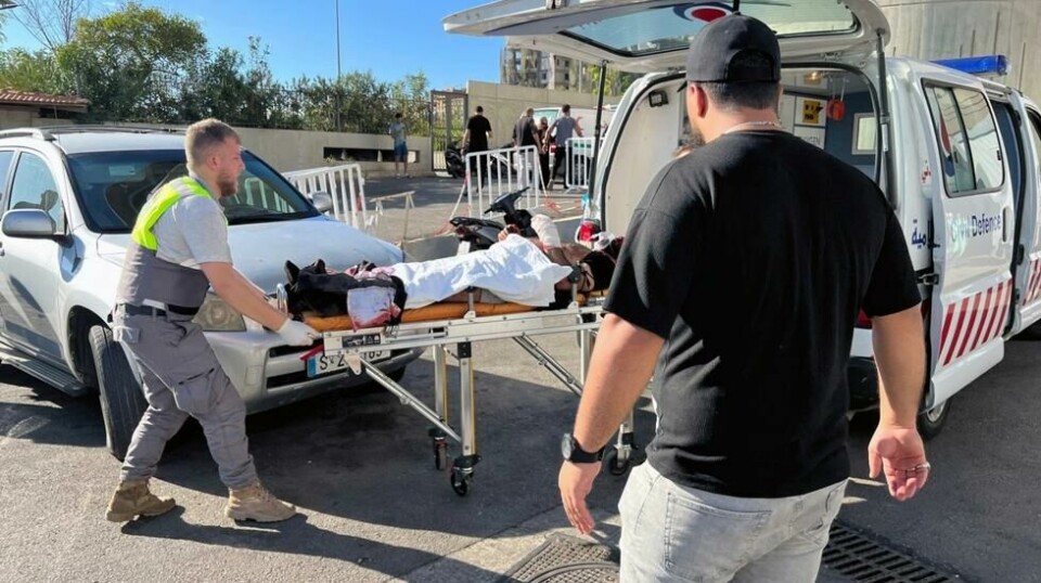 Libanesiske ambulansearbeidere bringer en såret mann til al-Zahraa-sykehuset i Beirut.