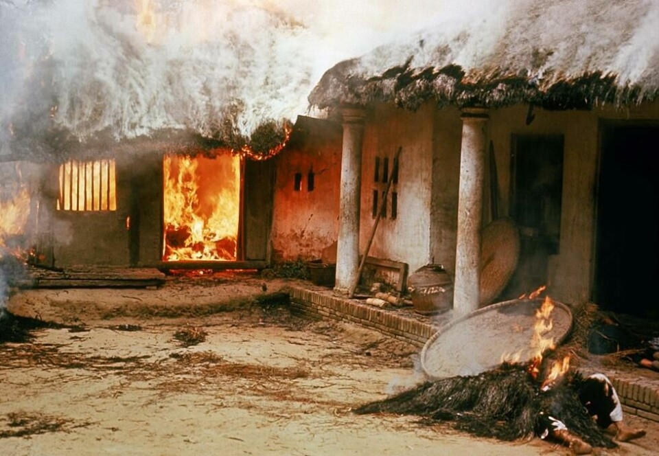 Amerikanske soldater fikk ordre om å brenne ned husene i My Lai. Det kom også meldinger om at flere av husene ble brent ned mens det fortsatt var folk fanget i dem. I forgrunnen er en død person som også brennes. Amerikanske soldater fikk ordre om å brenne ned husene i My Lai. Det kom også meldinger om at flere av husene ble brent ned mens det fortsatt var folk fanget i dem. I forgrunnen er en død person som også brennes. Foto: Ronald L. Haeberle
