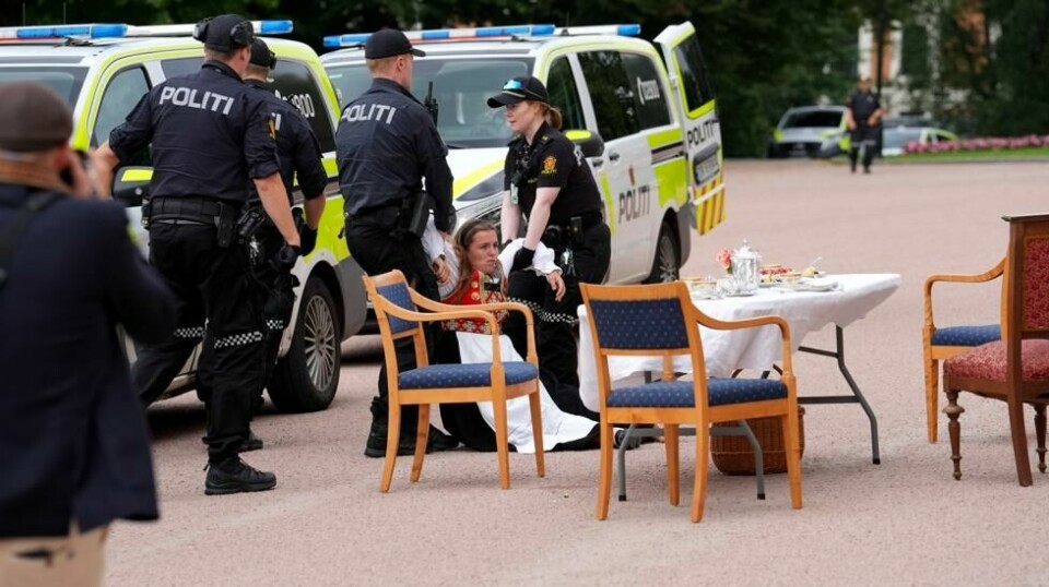En bunadskledd demonstrant blir båret bort av politiet. Foto: Lise Åserud / NTB