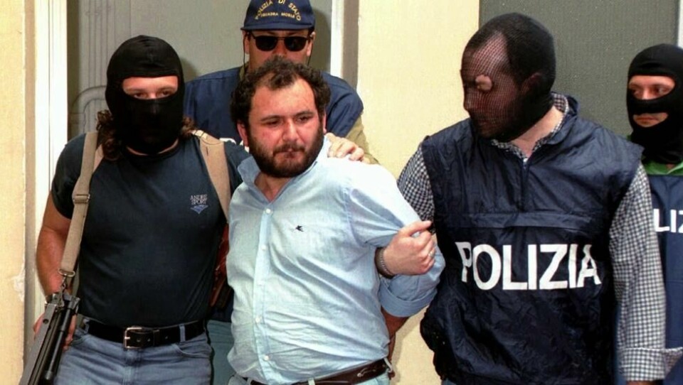 Giovanni Brusca eskorteres av maskerte politimenn utenfor politihovedkvarteret i Palermo på Sicilia, i dette bildet fra 21. mai 1996. Giovanni Brusca eskorteres av maskerte politimenn utenfor politihovedkvarteret i Palermo på Sicilia, i dette bildet fra 21. mai 1996. Foto: Alessandro Fucarini / AP Photo / NTB