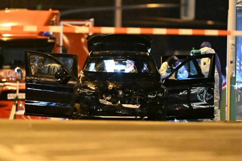 Etterforskere undersøker den svarte bilen som kjørte inn i julemarkedet.