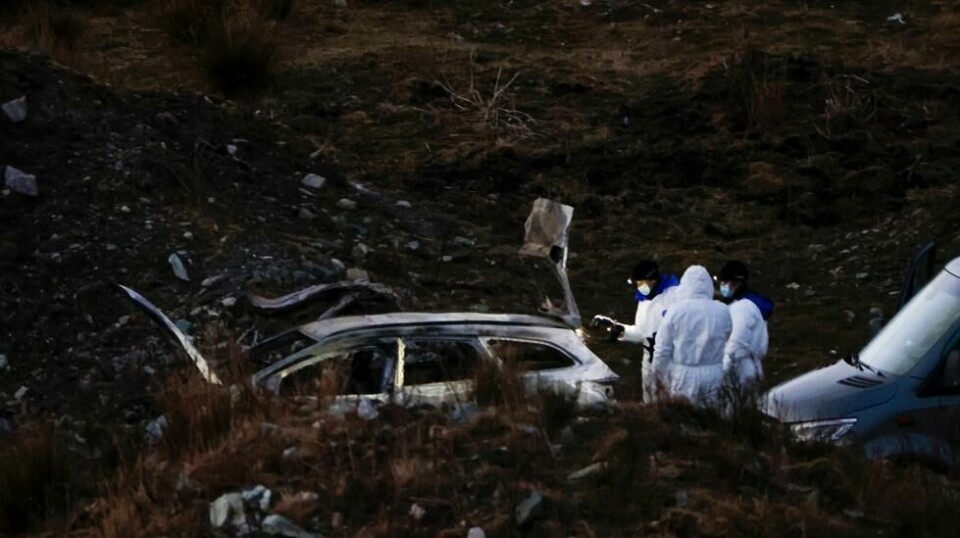 Politiet på stedet ved den utbrente bilen der kvinnen ble funnet død i bagasjerommet. Foto: Paul S. Amundsen / NTB