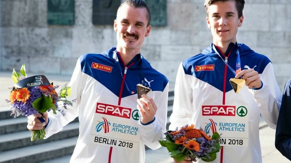 Henrik og Jakob Ingebrigtsen mottar sine medaljer fra 5000 meteren på Olympiastadion i Berlin søndag kveld.