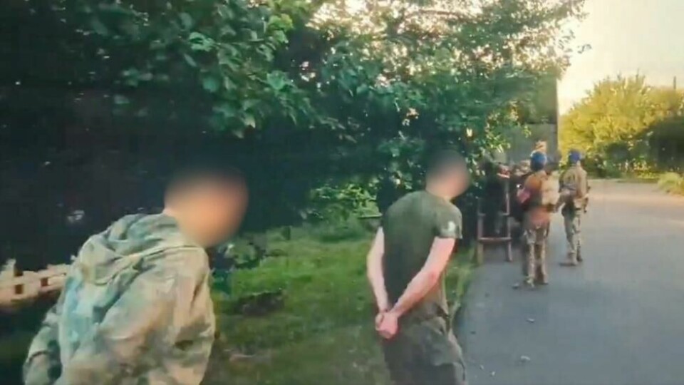 Mennene som blir geleidet inn i kjøretøyet med armene bundet på ryggen, har både sivile og militærliknende klær på seg. Mennene som blir geleidet inn i kjøretøyet med armene bundet på ryggen, har både sivile og militærliknende klær på seg. Foto: Skjermdump / X