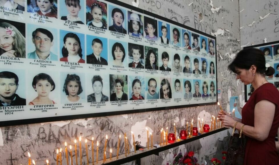 En kvinne tenner lys foran bildene av noen av de 334 som ble drept i skolemassakren i Beslan i Russland. En kvinne tenner lys foran bildene av noen av de 334 som ble drept i skolemassakren i Beslan i Russland. Foto: Musa Sadulayev / AP