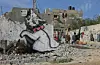 Banksy lot til å ha sneket seg inn på Gazastripen i 2015. Her er en av hans grafitti-kunstverk på en murvegg som ble ødelagt under en av Israels kriger mot Hamas-bevegelsen som styrer det palestinske territoriet. NTB Scanpix/AP.