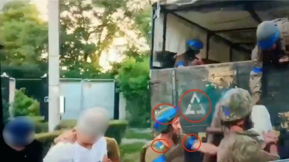 I videoen ser vi soldater med blå teip rundt armer og hjelmer, og ett ukrainsk flagg på en av uniformene. Kjøretøyet har også en hvit trekant på seg som er et symbol ukrainske soldater bruker. I videoen ser vi soldater med blå teip rundt armer og hjelmer, og ett ukrainsk flagg på en av uniformene. Kjøretøyet har også en hvit trekant på seg som er et symbol ukrainske soldater bruker. Foto: Skjermdump / X