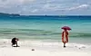 En turist poserer på stranda på øya Boracay, som president Duterte nylig beordret stengt for turister for å få renset opp miljøproblemer. Scanpix/Reuters.