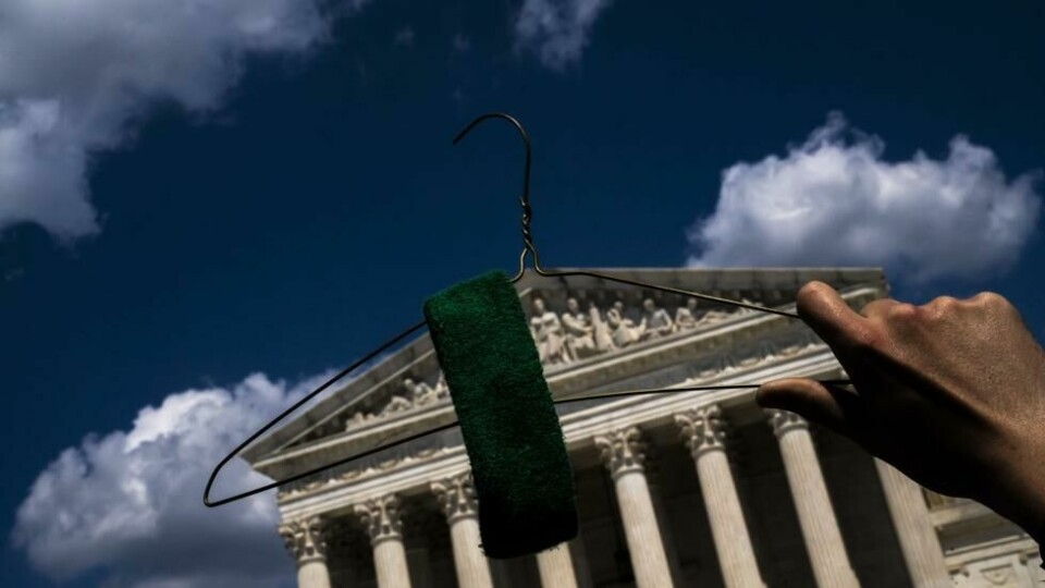En demonstrant holder en kleshenger opp foran Høyesterettsbygningen i Washington. En demonstrant holder en kleshenger opp foran Høyesterettsbygningen i Washington. Foto: Nathan Howard / Getty Images/AFP/NTB