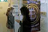 Folk bruker en bitcoin-minibank i Hong Kong fredag 8. desember 2017. Bitcoin er verdens mest populære virtuelle valuta. Slike penger er serier med datakode som signeres digitalt hver gang de brukes til handel. Scanpix/AP.