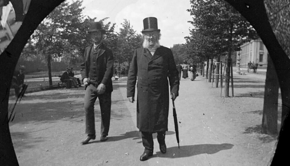 Henrik Ibsen på vandring ned Karl Johansgate i Oslo - iført bonjourfrakk. Henrik Ibsen på vandring ned Karl Johansgate i Oslo - iført bonjourfrakk. Foto: Størmer, Fredrik Carl Mülertz / Norsk Teknisk Museum