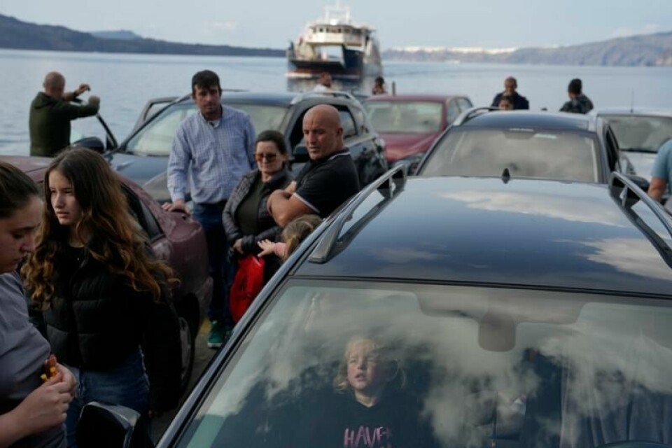 Folk venter på ferja til Aten ved havna i Santorini. Tusenvis har de siste dagene forlatt den greske ferieøya etter en lang rekke mindre jordskjelv.