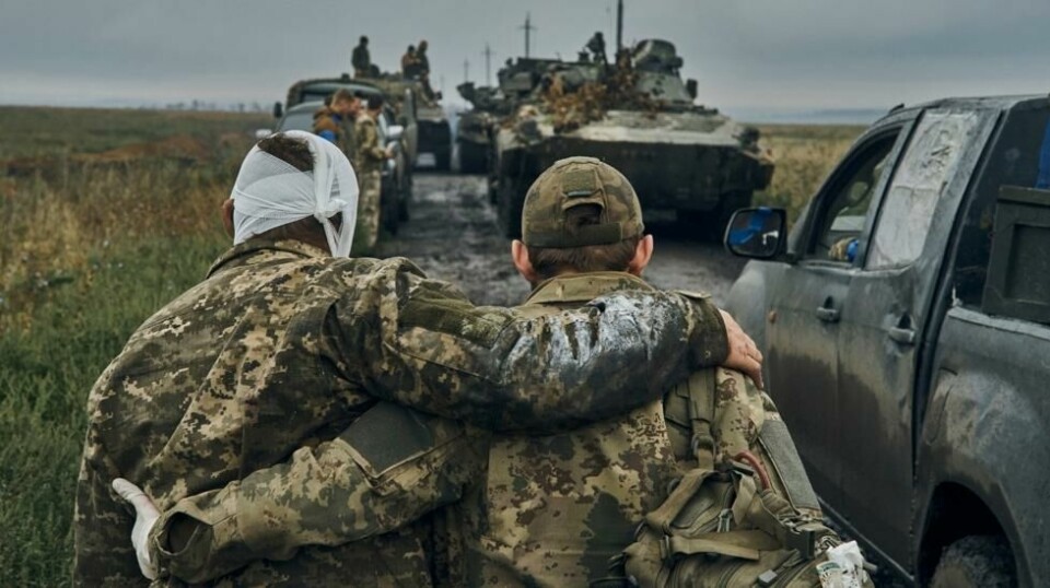En ukrainsk soldat hjelper en annen skadd soldat tilbake til kjøretøyene deres i Kharkiv-området. Artur er en del av styrkene i området.
