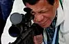 Filippinenes tidligere president Rodrigo Duterte ser gjennom kikkertsiktet til en kinesiskprodusert snikskytterrifle, ved en seremoniell overlevering av kinesiske våpen ved Clark Airbase nord på Filippinene, juni 2017. Scanpix/AP.