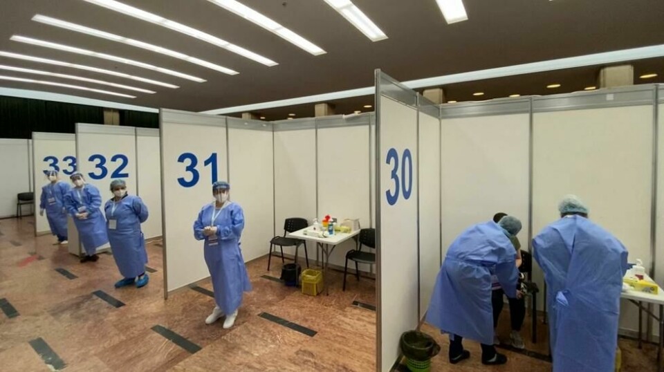 A man receives a Pfizer-BioNTech's Comirnaty COVID-19 vaccine as medical staff wait for patients at the “Sala Palatului” event hall in Bucharest, Romania on May 07, 2021, as Bucharest’s authorities start a vaccination marathon during the weekend. (Photo by Daniel MIHAILESCU / AFP)