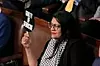 Kongresskvinne Rashida Tlaib holdt opp flere skilt for å protestere mot Israels statsminister Benjamin Netanyahu. Foto: J. Scott Applewhite / AP / NTB