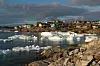 Fargerike trehus og små og store isklumper og -fjell i sjøen er kontrastfylt. Foto: Visit Greenland