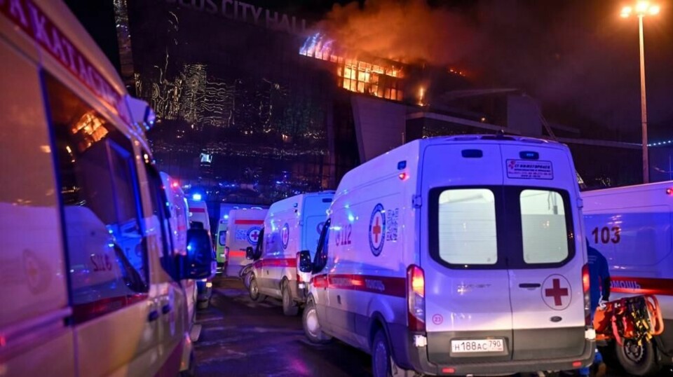 En rekke ambulanser sto ved den brennende bygningen fredag kveld for å frakte overlevende til sykehus. Foto: Dmitrij Serebrjakov / AP / NTB