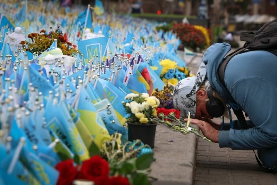 En ukrainsk kvinne deltar i ett minutts stillhet ved et minnested i Kyiv for de ukrainske soldatene som er drept i krigen mot Russland. Bildet ble tatt 1. oktober 2023.