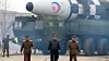 Nord-Koreas leder Kim Jong-un (i midten) viser fram det landet hevder er en interkontinental rakett av typen Hwasong-17 som kan utstyres med atomstridshode. Foto: KCNA / AP / NTB