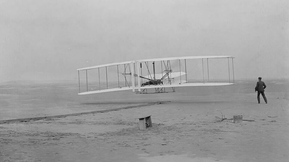 Klokken 10:35 17. desember 1903 fløt menneste i en flymaskin for første gang. Dette bildet er det eneste som ble tatt av det historiske øyeblikket. Pilot var Orville Wright, mens broren Wilbur løp ved siden av flyet.