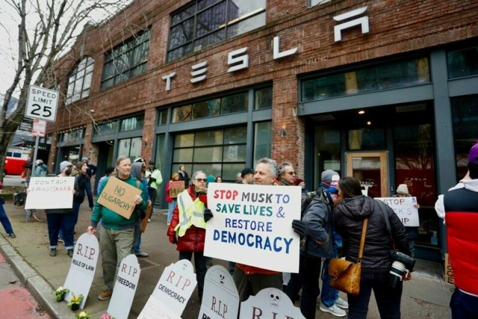 Folk demonstrerer mot Elon Musk utenfor en Tesla-butikk i Seattle i USA i februar. Salget svikter for bilmerket i Europa, noe som settes i sammenheng med Musks politiske aktivitet.