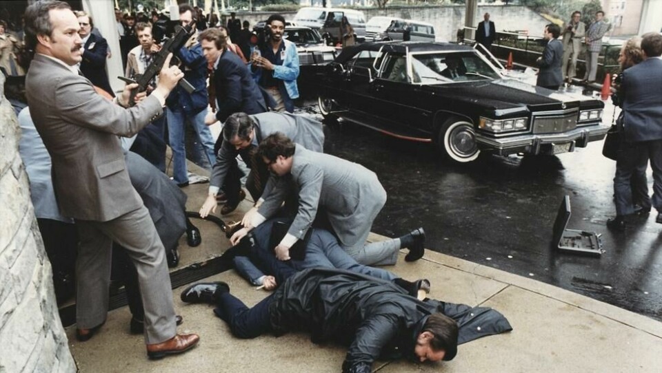 Sekunder etter attentatforsøket. På bakken ligger pressesekretæy James Brady og politibetjent Thomas Delahanty, som begge ble truffet av kuler. President Reagan ble raskt kastet inn i en limousin og fraktet til sykehus. Sekunder etter attentatforsøket. På bakken ligger pressesekretæy James Brady og politibetjent Thomas Delahanty, som begge ble truffet av kuler. President Reagan ble raskt kastet inn i en limousin og fraktet til sykehus. Foto: Ronald Reagan Presidential Library