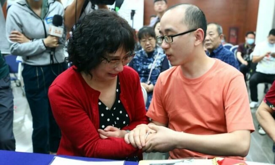 Li Jingzhi knuger sønnen hånd mens hun forteller at han aldri må forlate henne igjen. Mao Yin ble bortført fra foreldrene da han var 2 år gammel for 32 år siden. Foto: STR / AFP / China OUT Li Jingzhi knuger sønnen hånd mens hun forteller at han aldri må forlate henne igjen. Mao Yin ble bortført fra foreldrene da han var 2 år gammel for 32 år siden. Foto: STR / AFP / China OUT