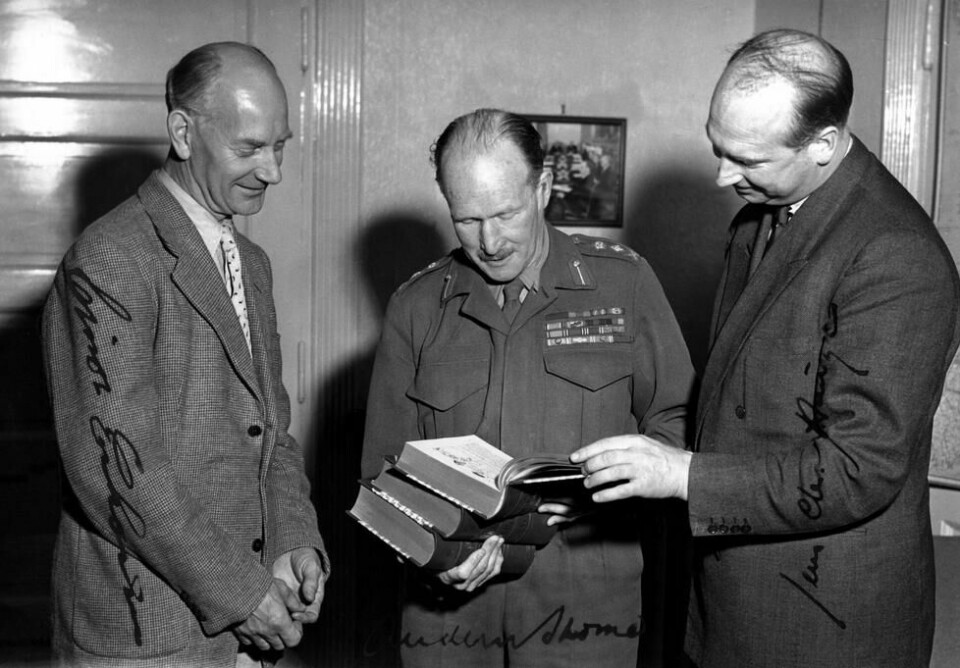 Einar Gerhardsen, general Andrew Thorne og Jens Christian Hauge studerer trebindsverket Norges krig 1940 - 45. Dette signerte fotografiet er fra 1951. Einar Gerhardsen, general Andrew Thorne og Jens Christian Hauge studerer trebindsverket Norges krig 1940 - 45. Dette signerte fotografiet er fra 1951. Foto: NTB scanpix